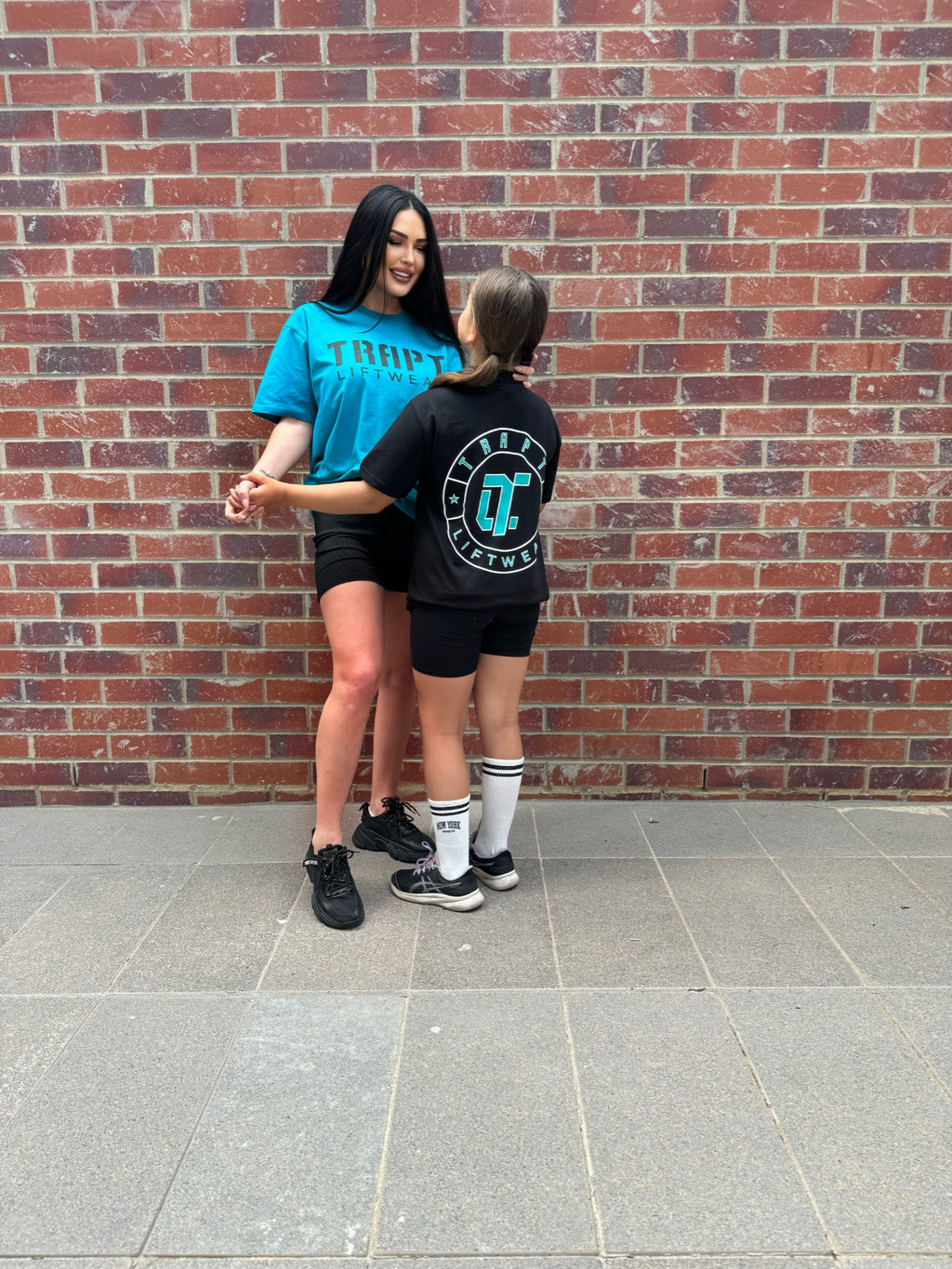 2 girls teal black shirts TRAPT 