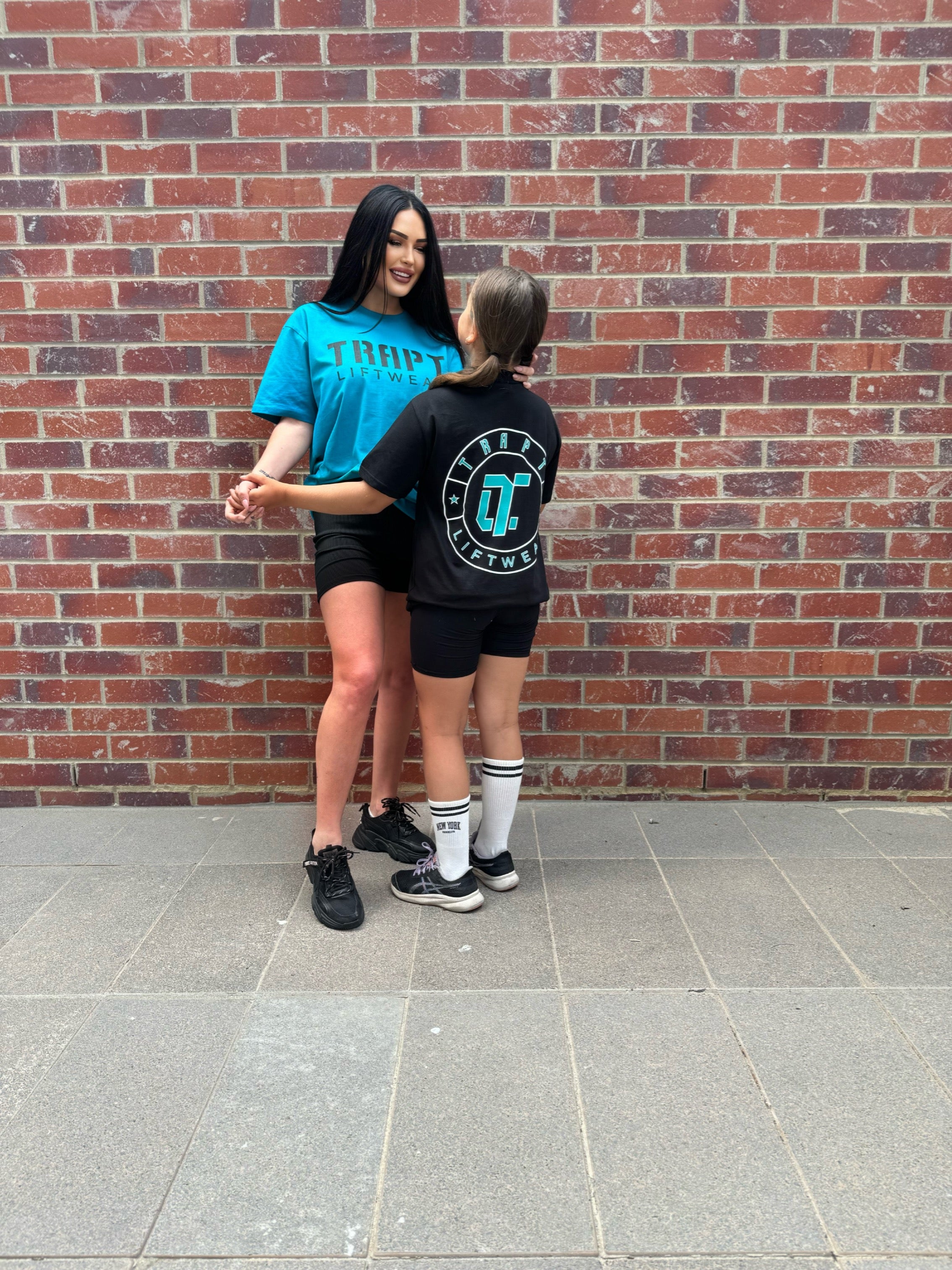 2 girls teal black shirts TRAPT 